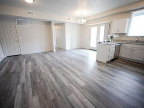 Tooele apartment for rent - A spacious room with wood flooring and white walls.