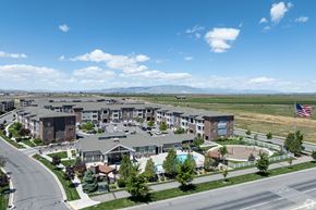Springville apartment for rent - an aerial view of an apartment complex with a pool and flag at Outlook Apartments for rent in Springville and Provo, UT.