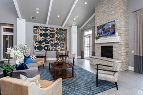 Springville apartment for rent - A living room with a stone fireplace and a large tapestry hanging on the wall.