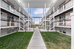 Ogden apartment for rent - A long white corridor with a walkway in the middle of apartment buildings.