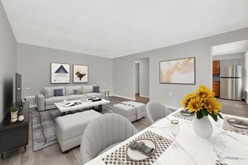 Ogden apartment for rent - A modern living room with a grey sofa set and a white dining table set with a vase of sunflowers.