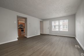 Ogden apartment for rent - A spacious empty room with wooden flooring and a doorway leading to another room.