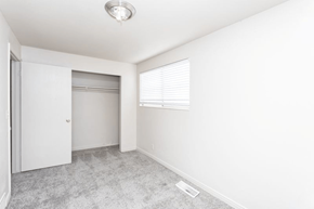 Salt Lake City townhouse for rent - A room with a white door, a window with blinds, and a carpeted floor.