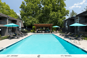 Bountiful apartment for rent - A large swimming pool surrounded by lounge chairs and umbrellas.