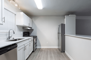 Bountiful apartment for rent - A kitchen with white cabinets and a black dishwasher.