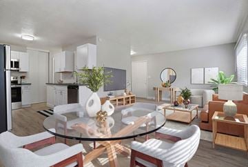 Roy apartment for rent - A modern living room with a glass table and white chairs.