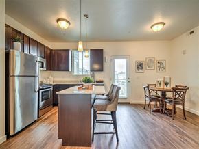 Roy apartment for rent - a kitchen with a large island and a stainless steel refrigerator at Aderra apartments for rent in Roy, Utah