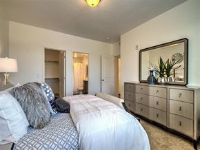 Roy apartment for rent - a bedroom with a bed and a yellow wall at Aderra apartments in Roy, Ut