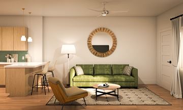 Rexburg townhouse for rent - A living room with a green couch and a round mirror on the wall.
