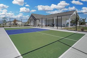 Tooele townhouse for rent - A tennis court with a building in the background.