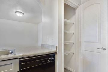 West Valley City apartment for rent - A kitchen with a black oven and white cabinets.