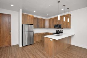 Bountiful apartment for rent - a kitchen with wooden cabinets and a stainless steel refrigerator