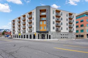 Bountiful apartment for rent - a grey apartment building with orange balconies and a blue sky in the background