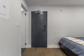 Hamilton apartment for rent - A bedroom with a bed and a black door.
