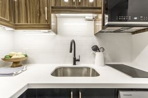 Hamilton apartment for rent - A modern kitchen with a stainless steel sink and wooden cabinets.