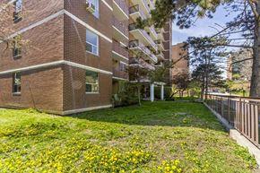 Mississauga apartment for rent - A brick building with a green lawn in front.