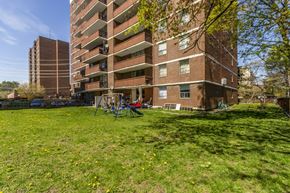 Mississauga apartment for rent - A grassy area in front of a brown brick apartment building.