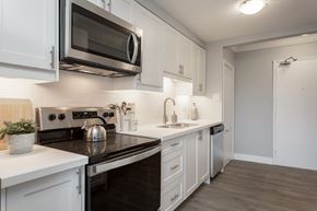 Hamilton apartment for rent - A kitchen with white cabinets and black countertops.