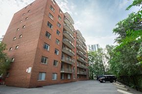 Hamilton apartment for rent - A red brick building with a black car parked in front.