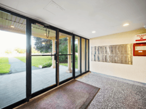 Brampton apartment for rent - A hallway with a red carpet and a glass door.