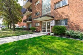 Hamilton apartment for rent - A red brick building with a green lawn in front.
