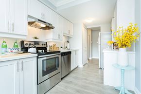 Hamilton apartment for rent - A kitchen with white cabinets and a stove top oven.