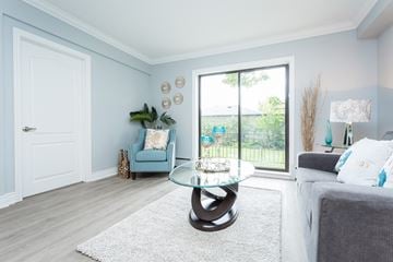 Hamilton apartment for rent - A living room with a blue chair and a glass table.
