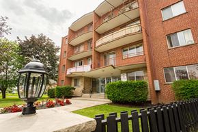 Hamilton apartment for rent - A red brick building with a black lamp post in front.