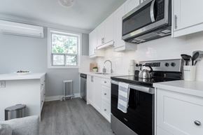 Hamilton apartment for rent - A kitchen with white cabinets and a black stove top oven.