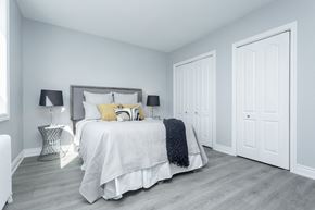 Hamilton apartment for rent - A bedroom with a bed, two lamps, and a nightstand.