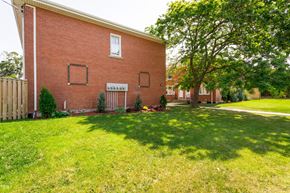 Hamilton apartment for rent - A red brick house with a white window and a white door.
