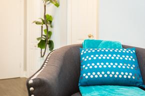 Hamilton apartment for rent - A grey couch with a blue pillow and a blue cushion on it.