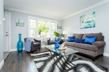Hamilton apartment for rent - A living room with a grey couch and a glass coffee table.