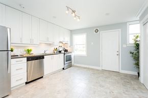 Hamilton apartment for rent - A kitchen with white cabinets and a stainless steel refrigerator.