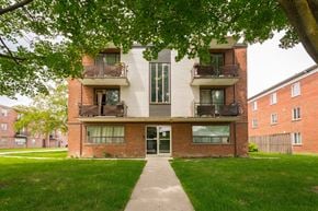 Hamilton apartment for rent - A building with a balcony and a tree in front of it.