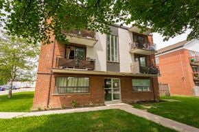 Hamilton apartment for rent - A red brick building with a balcony on the second floor.