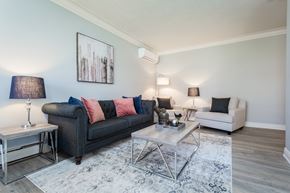 Hamilton apartment for rent - A living room with a black couch, a white chair, and a coffee table.