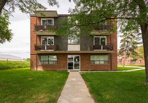Hamilton apartment for rent - A red brick building with a balcony on the second floor.