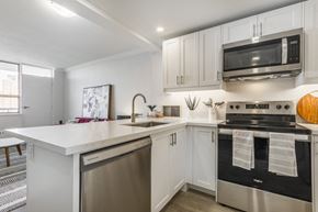 Toronto apartment for rent - A modern kitchen with a stainless steel oven and white countertops.