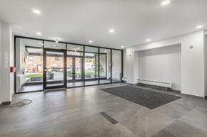 Toronto apartment for rent - A spacious room with a grey tiled floor and a large window with a view of the outside.