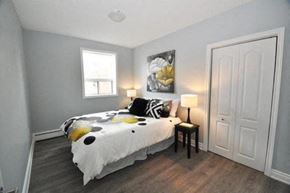 Hamilton apartment for rent - A bedroom with a bed, a lamp, and a painting on the wall.