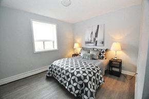 Hamilton apartment for rent - A bedroom with a bed, nightstand, and lamp.