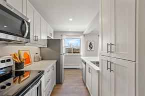 Brampton apartment for rent - A modern kitchen with white cabinets and stainless steel appliances.