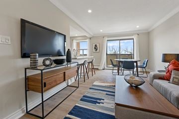 Brampton apartment for rent - A living room with a television on a stand and a couch.