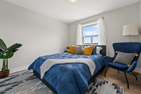 North York apartment for rent - A bedroom with a blue bedspread and a blue chair.