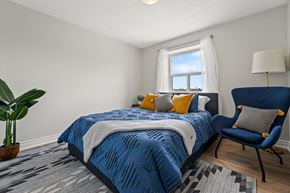 Brampton apartment for rent - A bedroom with a blue bedspread and a blue chair.