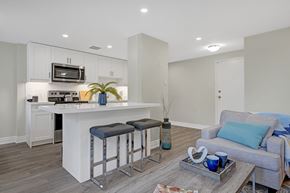Cambridge apartment for rent - A modern kitchen with white cabinets and a bar area.