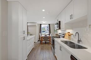 Hamilton apartment for rent - A kitchen with white cabinets and a wooden floor.