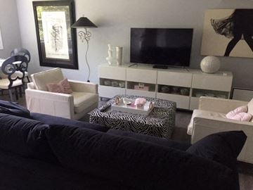 Hamilton apartment for rent - A living room with a black couch and a television on a cabinet.