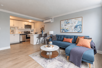 Hamilton apartment for rent - A living room with a blue couch and a painting on the wall.